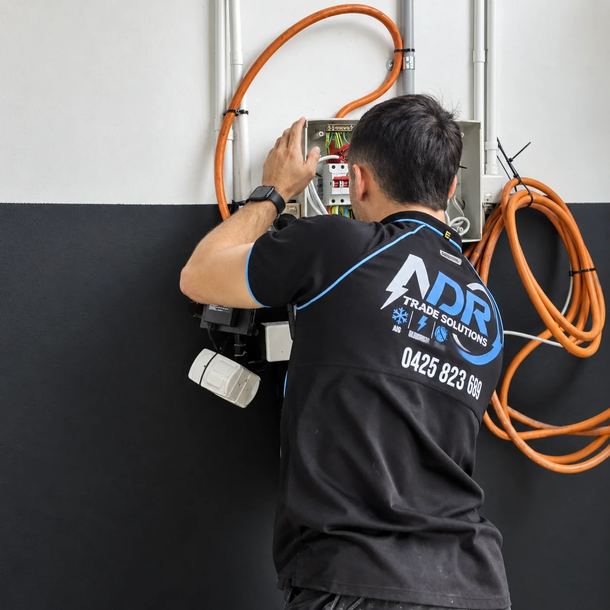 An NDR electrician assessing an electrical switchboard